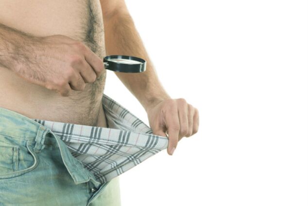 moški gleda svoj penis in si ga želi povečati